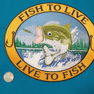 May include: A yellow and black embroidered patch with a bass jumping out of the water. The patch says "Fish to Live, Live to Fish" and has a fishing hook on each side.