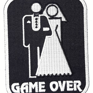 May include: Black and white embroidered patch with a stylized image of a bride and groom and the text "GAME OVER".