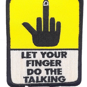 May include: A yellow and white embroidered patch with a black middle finger and the text "Let your finger do the talking".