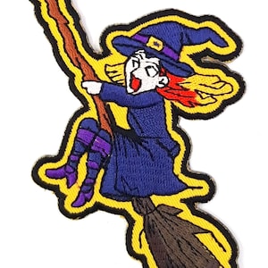 May include: A yellow embroidered patch of a cartoon witch flying on a broomstick. The witch is wearing a purple and blue dress, a pointed hat, and has red hair.