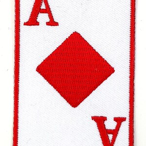 May include: A red embroidered patch of the Ace of Diamonds playing card. The card is white with a red border and the suit symbol is in the center.