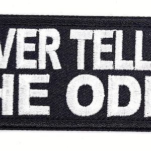 May include: Black embroidered patch with white text that reads "Never Tell Me The Odds".