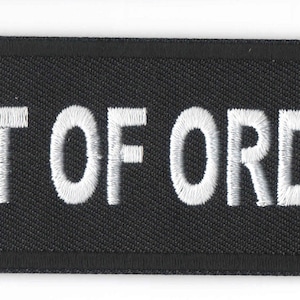 May include: Black fabric patch with white embroidered text that reads "OUT OF ORDER".