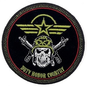 May include: Black and green embroidered patch with a white skull wearing a green helmet and crossed rifles. The patch has a green star and wings with the text "Duty Honor Country" in a red circle.