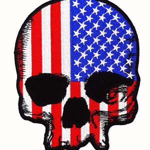 May include: Embroidered patch of a skull with the American flag design. The skull is black with white teeth and the flag is red, white, and blue.