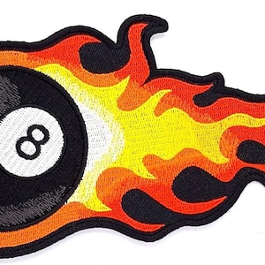 May include: A black and white eight ball on fire. The eight ball is surrounded by orange and yellow flames.