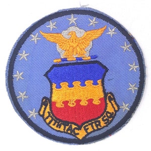 May include: A blue and white embroidered patch with a yellow eagle, a shield with red, yellow, and blue colors, and the text "10th TAC FTR SQ".