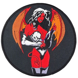 May include: Embroidered patch featuring a red-skinned, winged demon woman with a white and red outfit, holding a purple object. The background is black.
