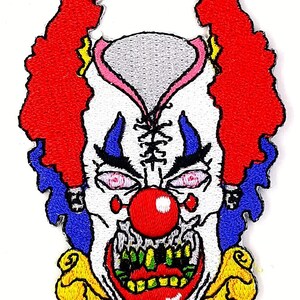 May include: Embroidered iron-on patch of a scary clown face with red hair, a white face, a red nose, and a wide, toothy grin. The clown's eyes are wide and black, and the mouth is open, revealing sharp teeth.