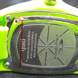 May include: Close-up of the back of a green Chronotech watch with a stainless steel back. The watch is water resistant to 3 ATM. The watch has a registered design.