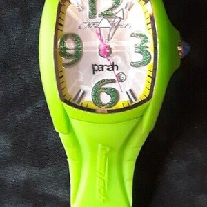 May include: A bright green wristwatch with a white face and black numbers. The watch has a silver buckle and a green band.