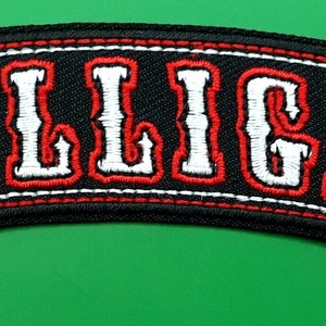 May include: Black embroidered patch with white lettering that reads "BILLIGAF" with red stitching around the edges.