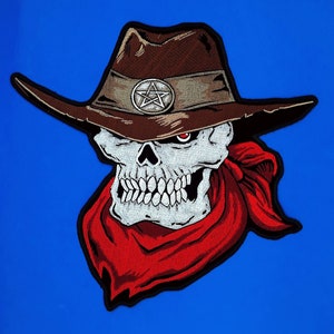 May include: Embroidered patch of a skull wearing a brown cowboy hat with a pentagram design and a red bandana.