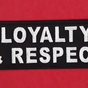 May include: Black embroidered patch with white stitching that reads "LOYALTY & RESPECT".