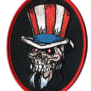 May include: A black and red embroidered patch with a skull wearing a red, white, and blue top hat. The skull has red eyes and a white beard.