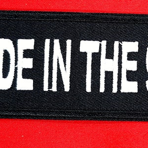 May include: Black fabric patch with white text that reads "MADE IN THE 90'S".
