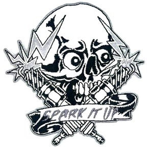 May include: Black and white embroidered patch featuring a skull with lightning bolts and crossed spark plugs. The banner below reads "Spark It Up".