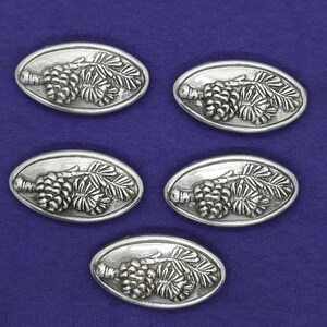 May include: Five silver-toned metal ornaments shaped like pine cones with needles. Each ornament has a detailed design of a pine cone with needles.