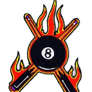 May include: Embroidered patch with a black 8-ball surrounded by flames and two crossed pool cues with purple tips.