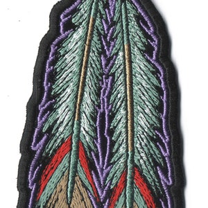 May include: Embroidered patch featuring a dreamcatcher design with two feathers. The patch has a black border, with the dreamcatcher in shades of brown and the feathers in green, red, and brown.