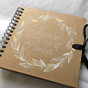 Livre d'or en kraft personnalisé avec prénoms pour mariage avec détails blancs et dorés