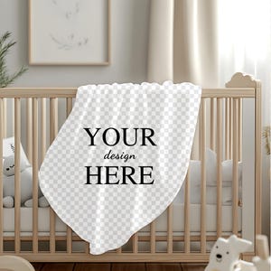 K&ouml;nnte beinhalten: Eine wei&szlig;e Babydecke mit dem Text "YOUR design HERE" in schwarzen Buchstaben. Die Decke liegt &uuml;ber einem Holz-Babybett.