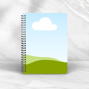 May include: A blue and green spiral bound notebook with a white cloud and green hills on the cover.
