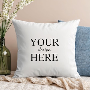 May include: White pillow with the text "YOUR design HERE" printed in black.