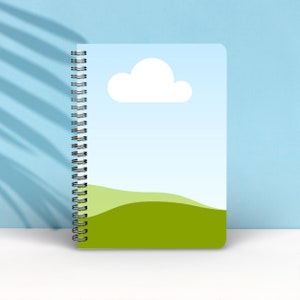 May include: A spiral bound notebook with a blue cover featuring a white cloud and a green grassy hill.