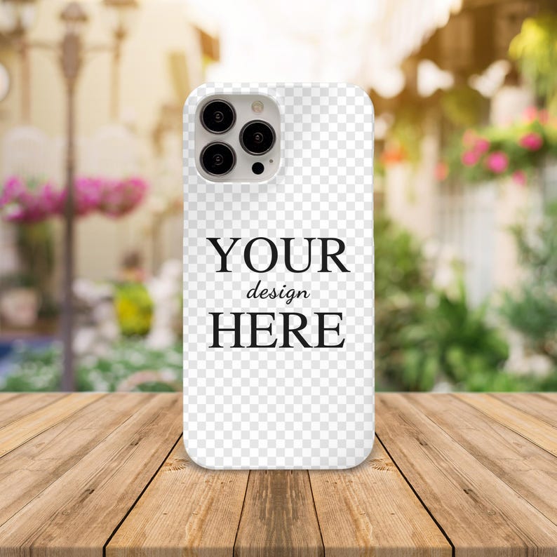 May include: White phone case with a clear back and a black camera bump. The case has the text "YOUR design HERE" printed on the back.