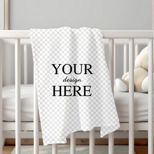 K&ouml;nnte beinhalten: Wei&szlig;e Babydecke mit dem Text "YOUR design HERE" auf einem wei&szlig;en Babybett.
