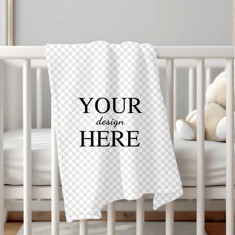 K&ouml;nnte beinhalten: Wei&szlig;e Babydecke mit dem Text "YOUR design HERE" auf einem wei&szlig;en Babybett.