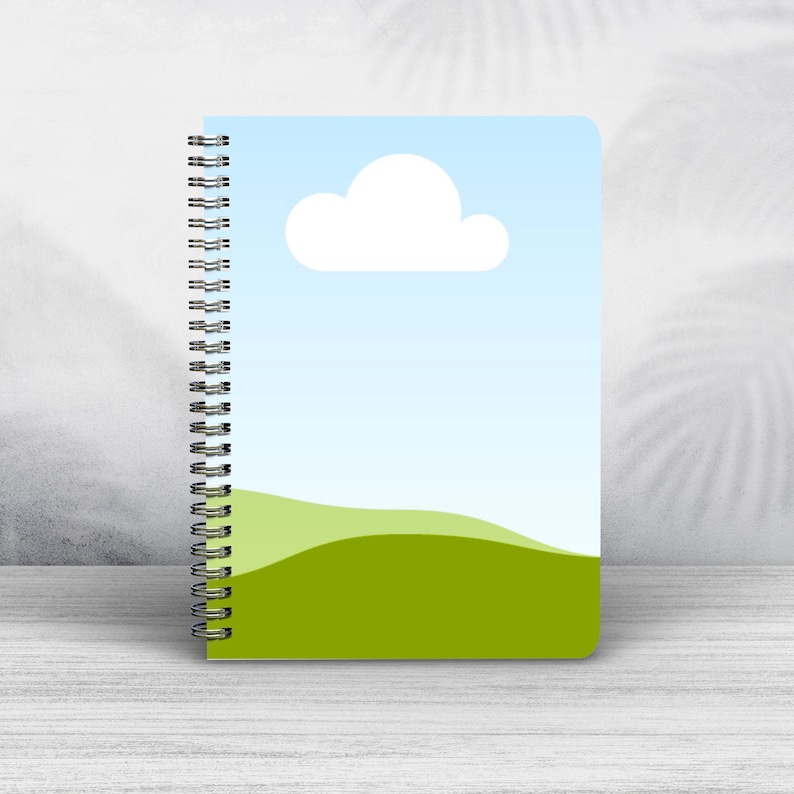 May include: A blue and green spiral bound notebook with a white cloud and a green hill design.