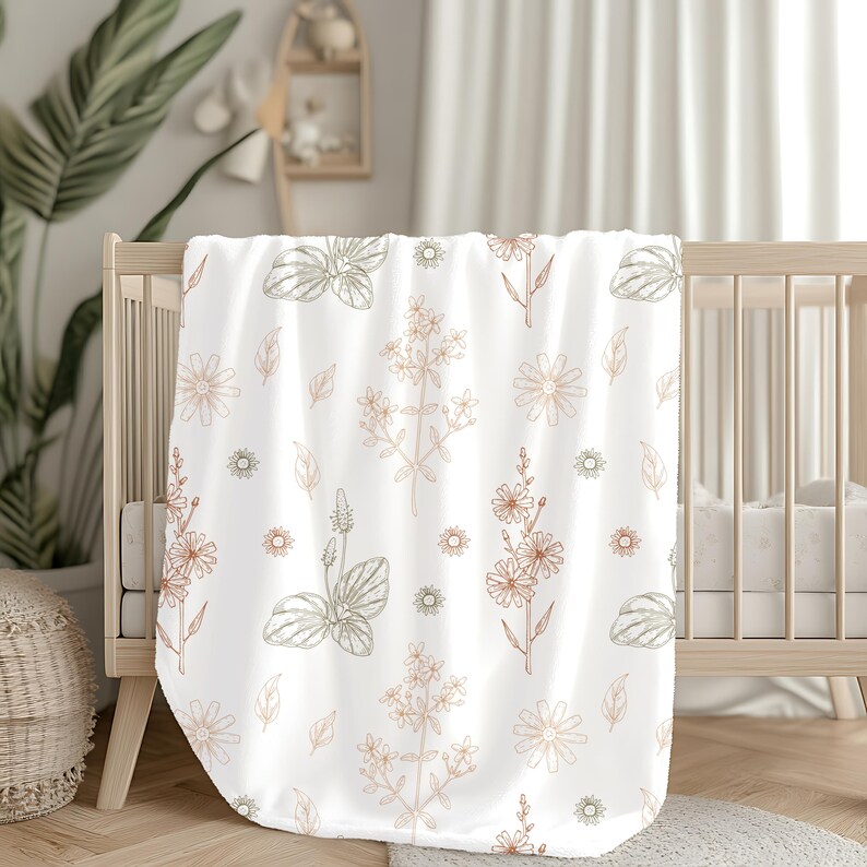 May include: A white baby blanket with a floral pattern in shades of brown and green. The blanket features a repeating pattern of flowers, leaves, and stems.