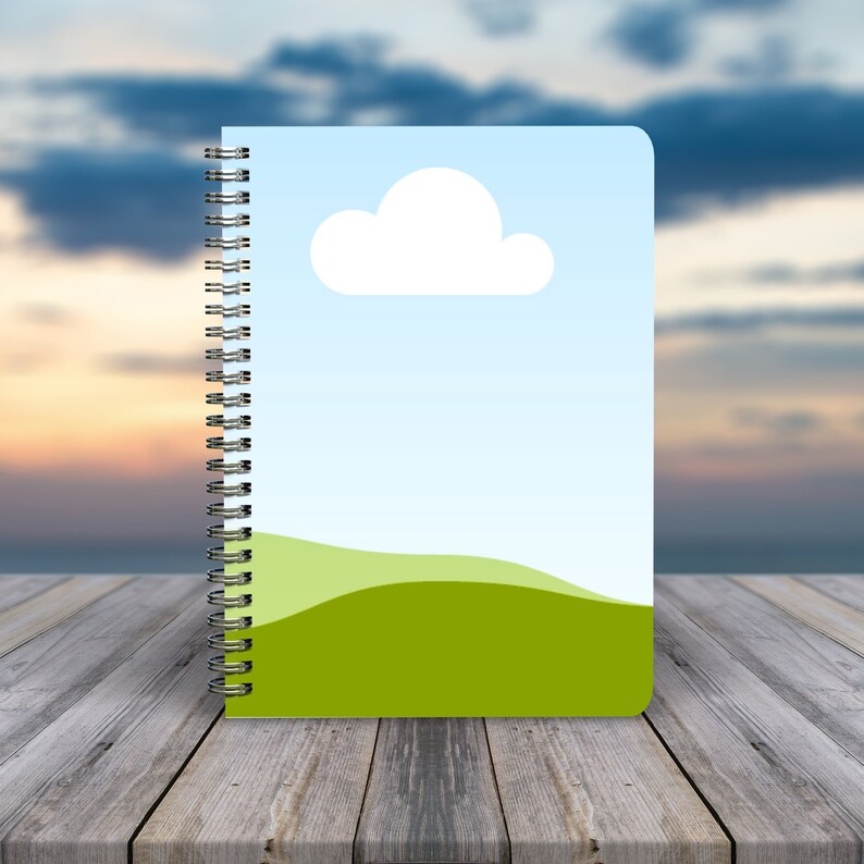 May include: A blue and green spiral bound notebook with a white cloud and a green hill design.