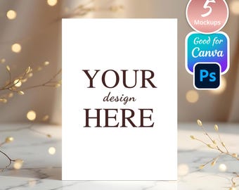 May include: A white card mockup with the text "YOUR design HERE" on a marble surface with a blurred background of white lights and branches.