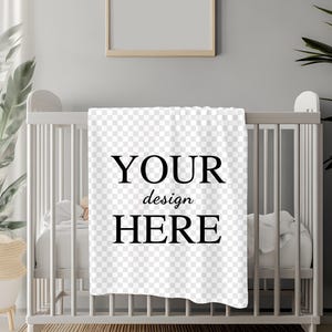 May include: White baby blanket with black text that says "YOUR design HERE" on a white crib.