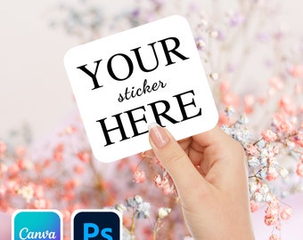 May include: A white square sticker with the text "YOUR sticker HERE" in black lettering. The sticker is being held by a hand against a background of pink and white flowers.