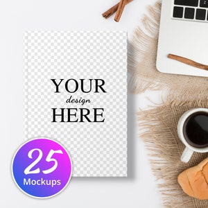 Puede incluir: Una maqueta blanca de un libro con el texto "YOUR design HERE" y un círculo morado y azul con el texto "25 Mockups". El libro está sobre una superficie blanca con una tela de arpillera marrón y un ordenador portátil en el fondo.