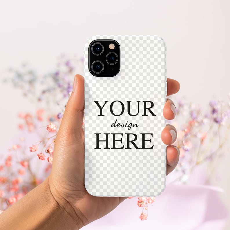 Peut inclure: Une coque de t&eacute;l&eacute;phone blanche avec un dos transparent et un objectif d'appareil photo noir. La coque porte l'inscription "YOUR design HERE" imprim&eacute;e sur le devant.