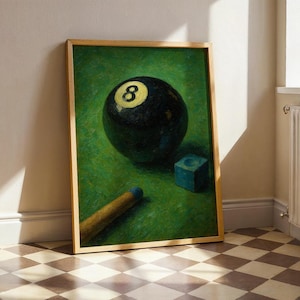 May include: A framed print depicting a black eight ball with a yellow '8', a blue chalk cube, and a pool cue on green baize. The artwork is in a wooden frame, suitable for interior display.