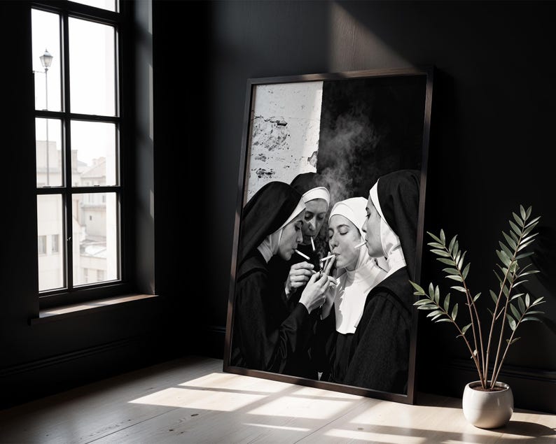 May include: Black and white framed print featuring a group of nuns smoking cigarettes. The image shows the nuns in their traditional habits, with smoke rising from the lit cigarettes. The artwork is displayed in a dark room with a window.