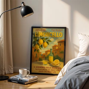 Peut inclure: Une affiche encadr&eacute;e "Limoncello" avec du texte italien, repr&eacute;sentant des citrons, une bouteille et un verre de la boisson. Un lampadaire noir et une tasse blanche sur des livres sont au premier plan.
