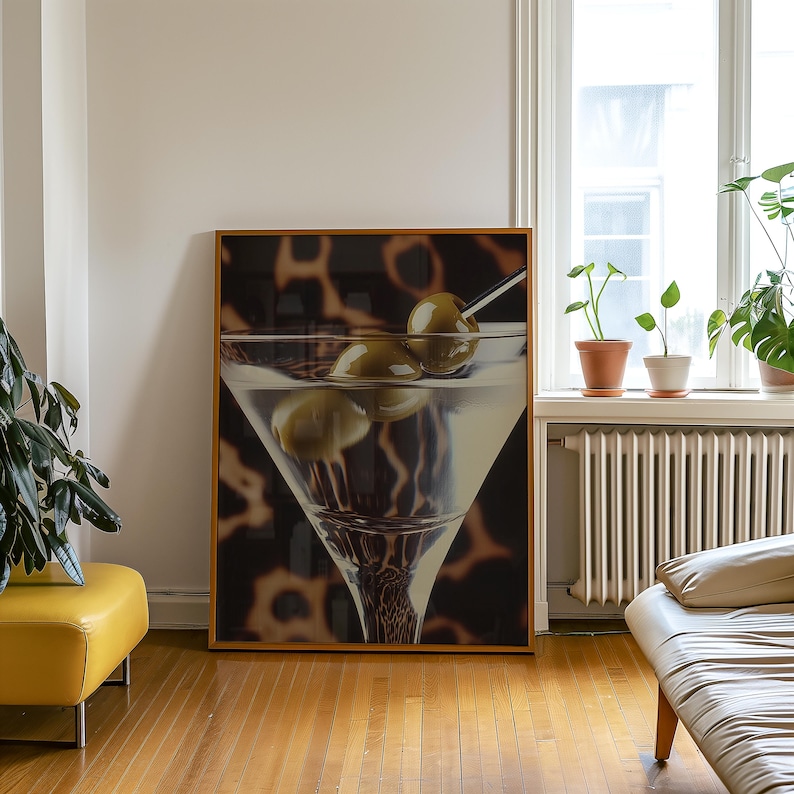 May include: A framed print of a martini glass with three green olives. The background is a blurred image of a leopard print.