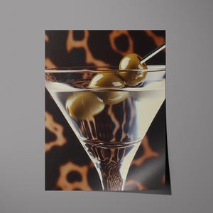 May include: A martini glass filled with a clear liquid and garnished with two green olives on a toothpick. The glass is sitting on a brown and black patterned surface.