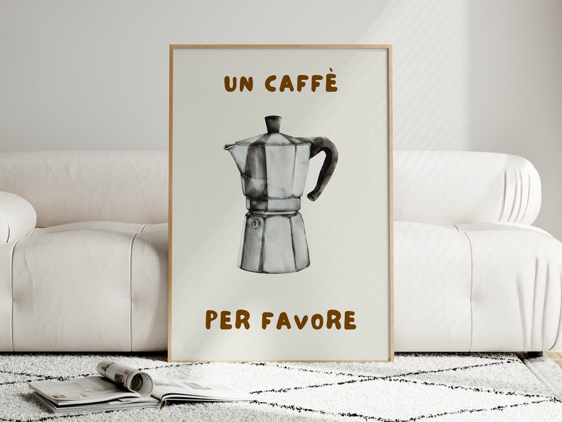 May include: A white poster with brown text that reads "UN CAFFE' PER FAVORE". A black and white illustration of a coffee pot is in the center of the poster.