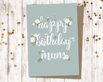 May include: A light blue card with white floral accents and the text "happy birthday mum" in white script.