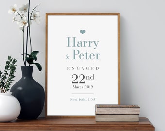 May include: A framed print with a white background and a blue heart at the top. The text reads "Harry & Peter Engaged 22nd March 2019 New York, USA".