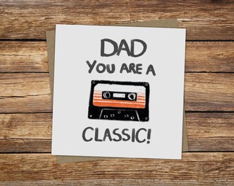 May include: A white card with black text that reads "Dad you are a classic!" and a black and orange cassette tape illustration.