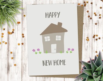 May include: A white card with the text "Happy New Home" and a simple illustration of a brown house with a chimney and two windows. The house is surrounded by green grass and three purple flowers.
